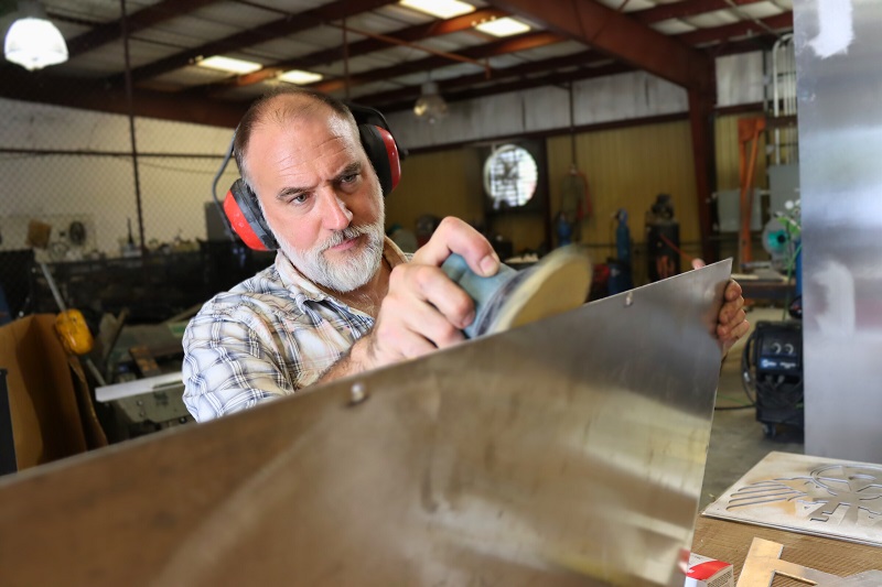 Master Craftsman Mark Dickson in the studio finishing panel elements